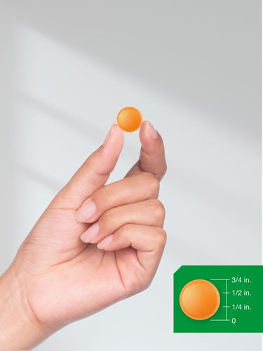 Hand holding an orange gelatin capsule with size measurement inset.