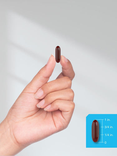 View 11 Hand holding a brown pill with size measurement inset on a light gray background