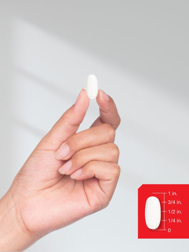 Hand holding a small white object with measurement scale on a plain background