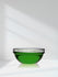 Glass bowl with green liquid on a white background
