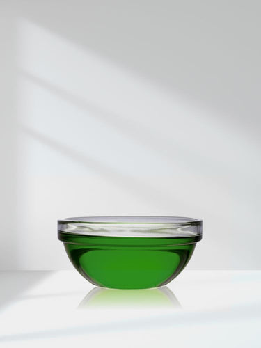 Glass bowl with green liquid on a white background