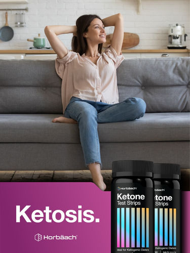 Woman sitting on a couch in a kitchen with ketone test strips in the foreground.