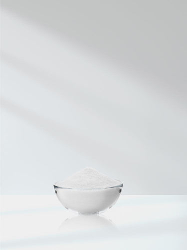 Glass bowl with white powder on a white background