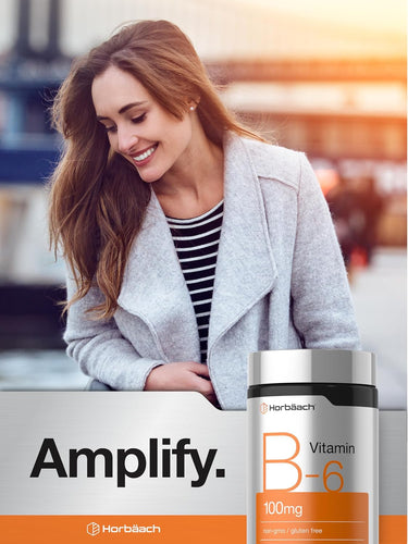 View 6 Young woman smiling outdoors, looking at a Horbaach Vitamin B6 bottle in her hand.