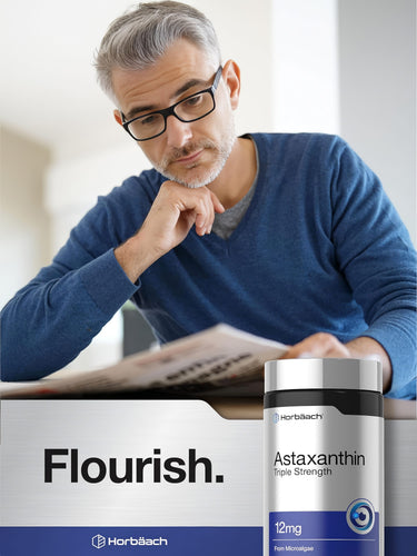 View 6 A middle-aged man sits and reads while holding a bottle of Astaxanthin supplement, portraying a healthy lifestyle choice.