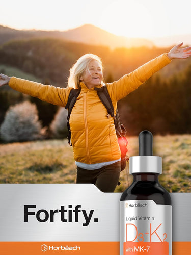 Person in yellow jacket with arms outstretched in a scenic setting, Fortify supplement bottle displayed.