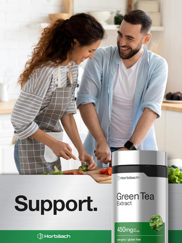 View 6 Young adult couple smiling while cooking in a kitchen, chopping vegetables, with a Horbaach Green Tea Extract bottle visible.