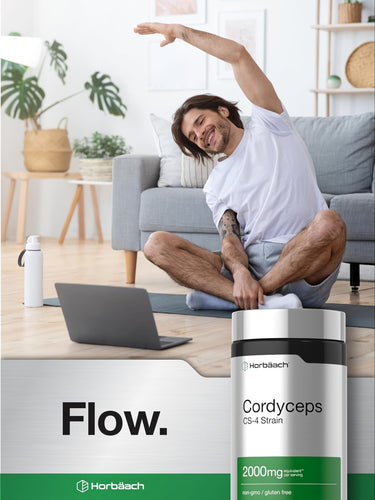 View 6 Young man stretching in a living room with a Cordyceps supplement bottle nearby.