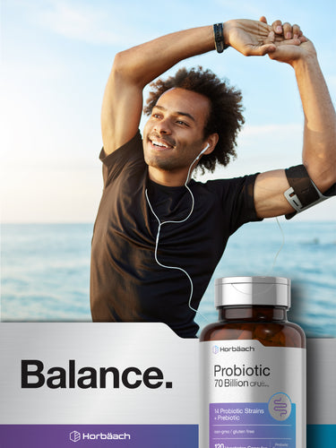 View 6 A young man stretches by the ocean with a Horbäach Probiotic 70 Billion CFU bottle nearby.