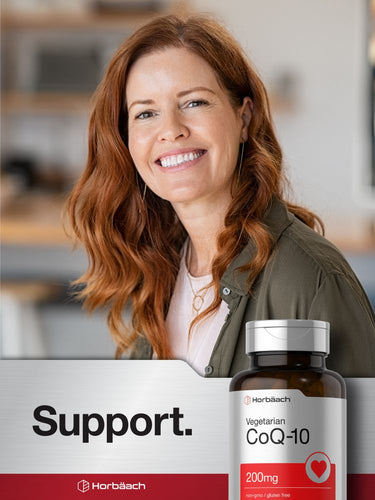 Woman smiling with a bottle of CoQ-10 supplement in the foreground.
